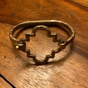 Gold colored bangle with hook clasp